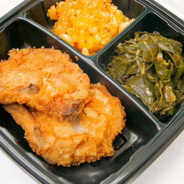 Bubba's Bistro southern meal with fried chicken, mac and cheese, and collard greens in a takeout container.