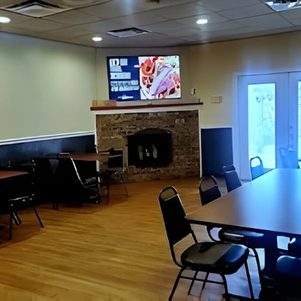 Bubba's Bistro dining room with tables, chairs, a fireplace, and a large TV screen.