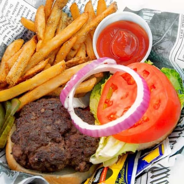 Bubba's Bistro's open-faced burger with fries, ketchup, pickles, lettuce, tomato, and onion.